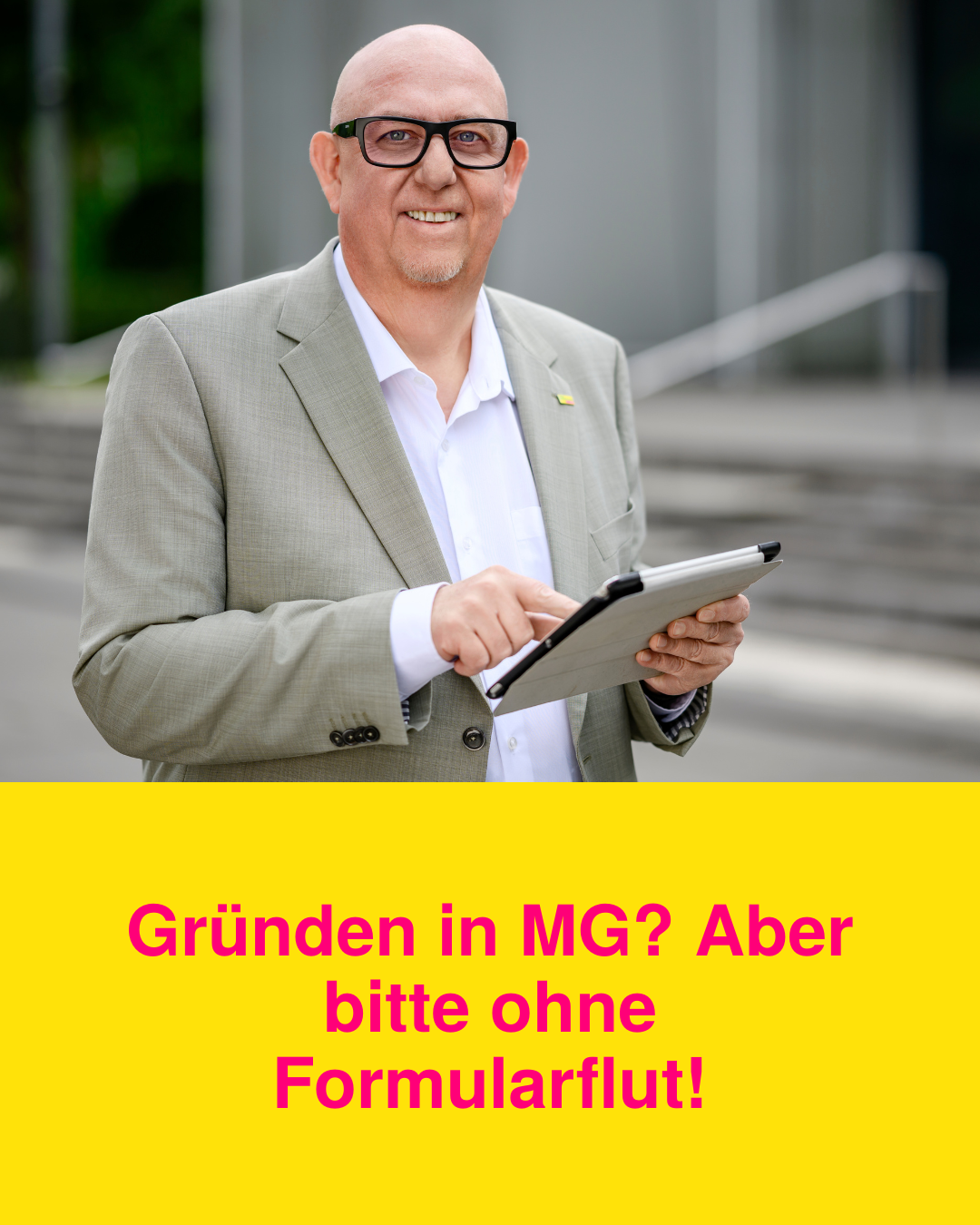 Reiner Gutowski hält ein Tablet mit der Kachel „Mehr Gründergeist für MG – Bürokratie war gestern!“ – für digitale Gründungsoffensive in Mönchengladbach.